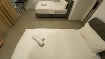 Een hotelkamer met een groot bed, een kleiner bed en een badkamer.