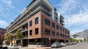A multi-story building with a prominent 'The Docklands' sign, featuring balconies and a brick facade. - The Docklands 509 by CTHA (Cape Town)