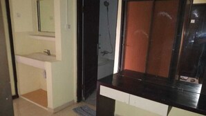 Une pièce équipée d’un lavabo, d’une fenêtre et d’une porte donnant accès à un espace douche.