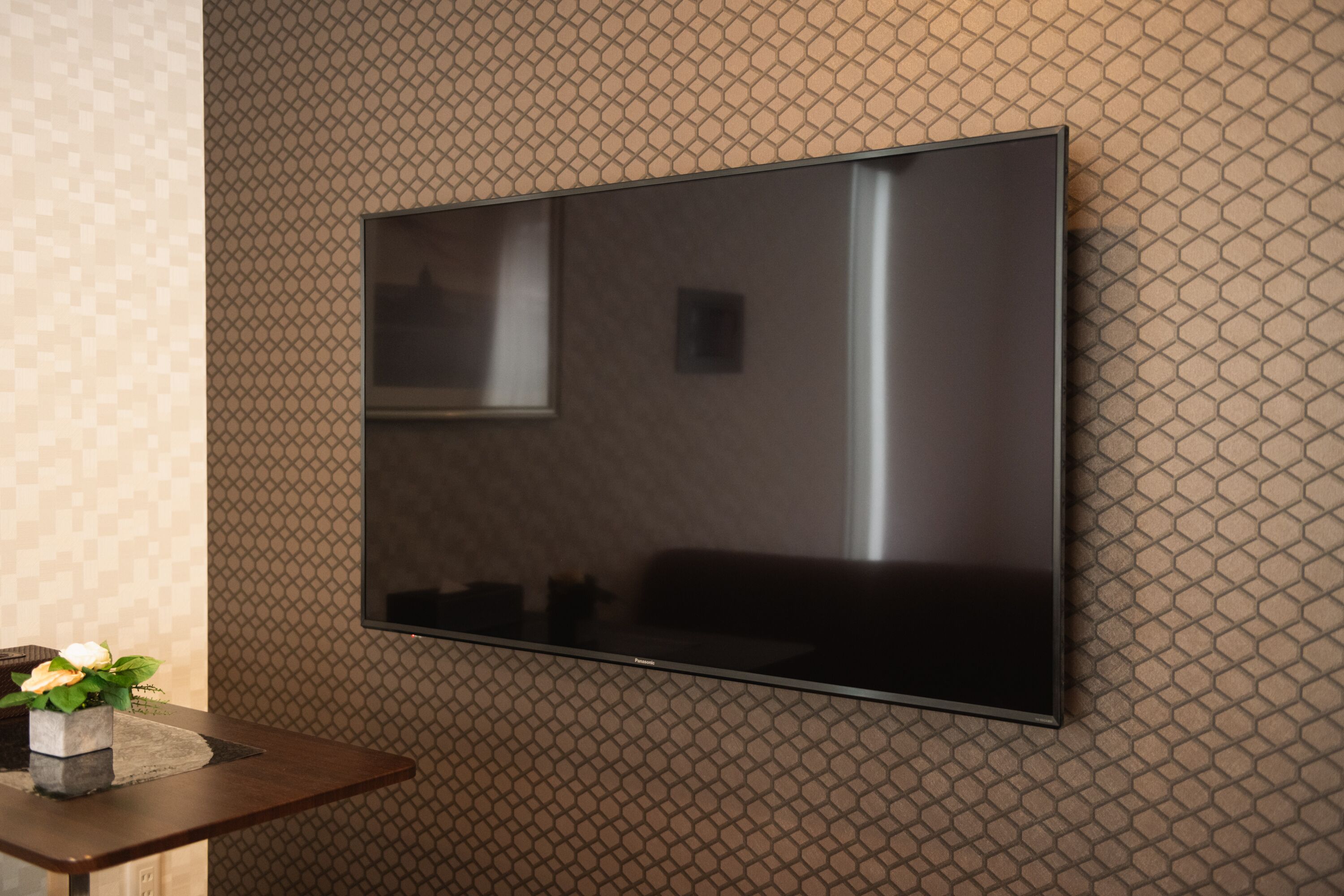 A flat-screen TV mounted on a textured wall.