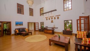 Uma sala de estar ampla com móveis de madeira, uma janela grande e um relógio de parede.