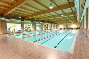 Una piscina cubierta, una piscina al aire libre de temporada, tumbonas
