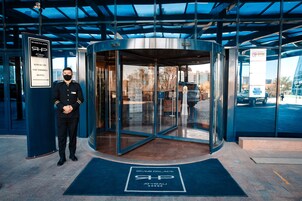 Una puerta giratoria de acceso a un hotel con un cartel que indica el nombre 'River Palace' y la página web 'atyrau.ru'.