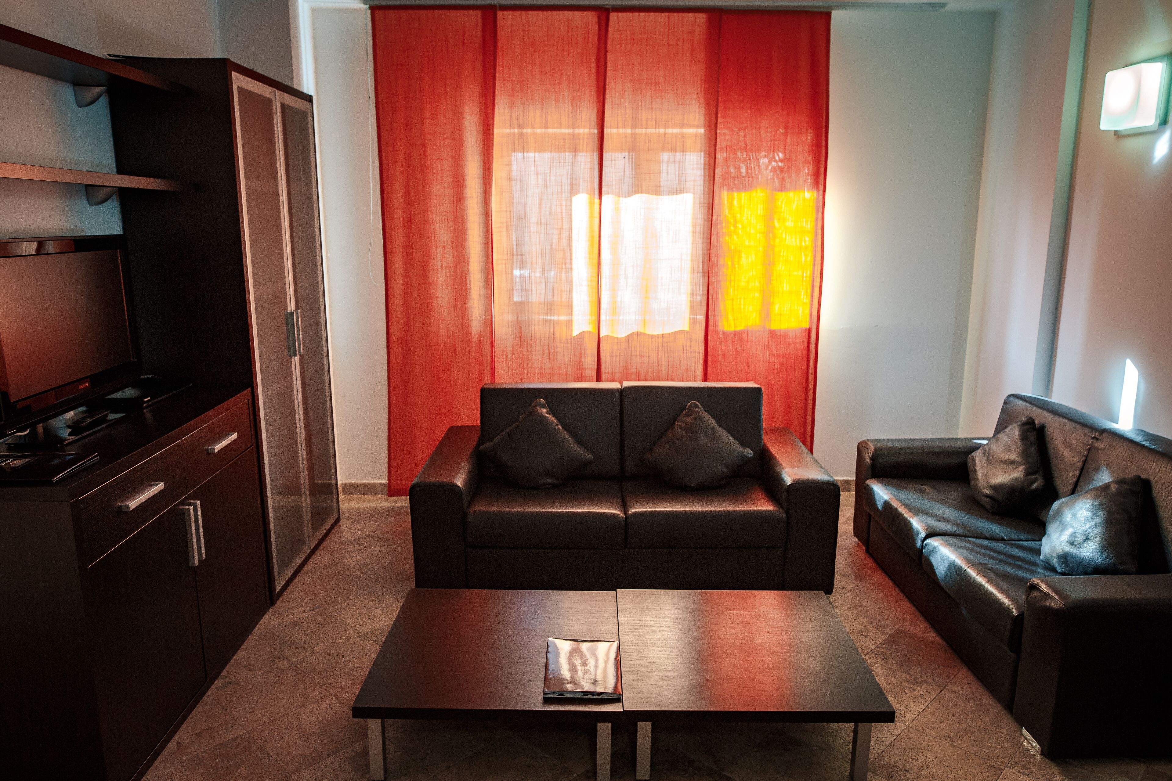 Ein modernes Wohnzimmer mit einer Couch, einem Couchtisch und einem Fernseher.