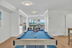 A pool table with a blue felt surface, a white cue ball, and a colorful arrangement of billiard balls.