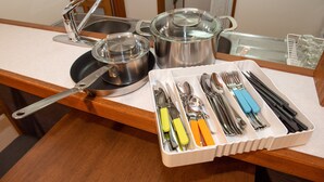 Una encimera de cocina con ollas, sartenes y un organizador de utensilios.