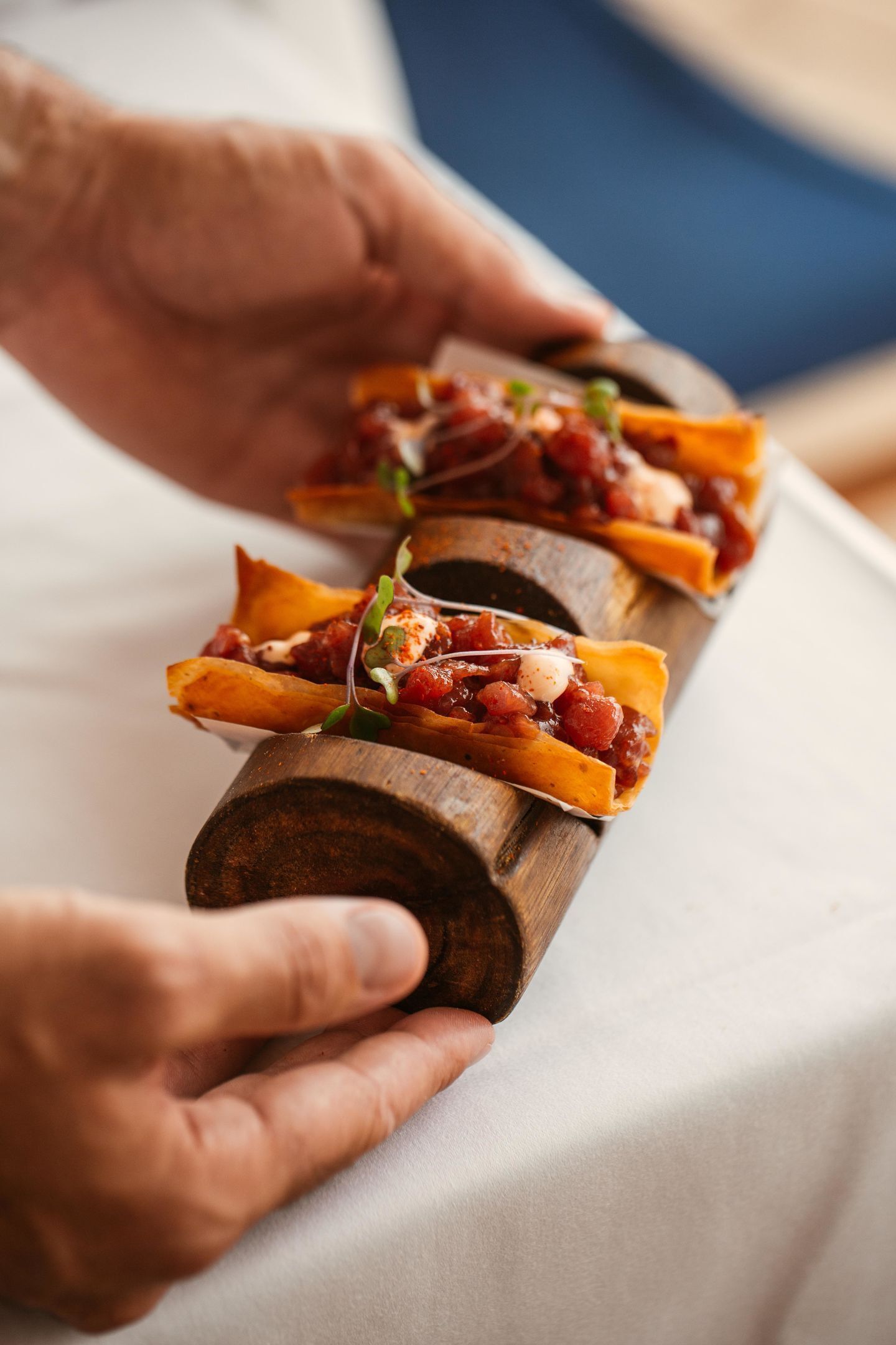 A wooden serving board with food items.