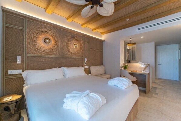 Una habitación de hotel moderna con una cama grande, un escritorio y un espejo.
