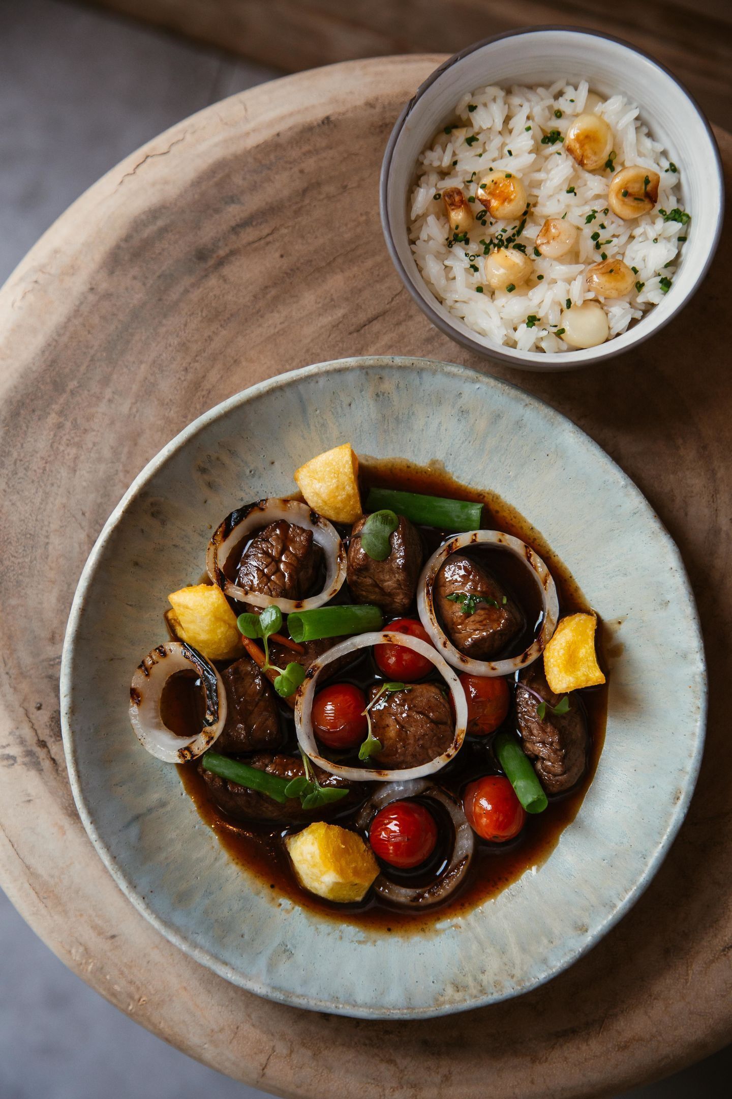 A bowl of white rice with scallops and chives.