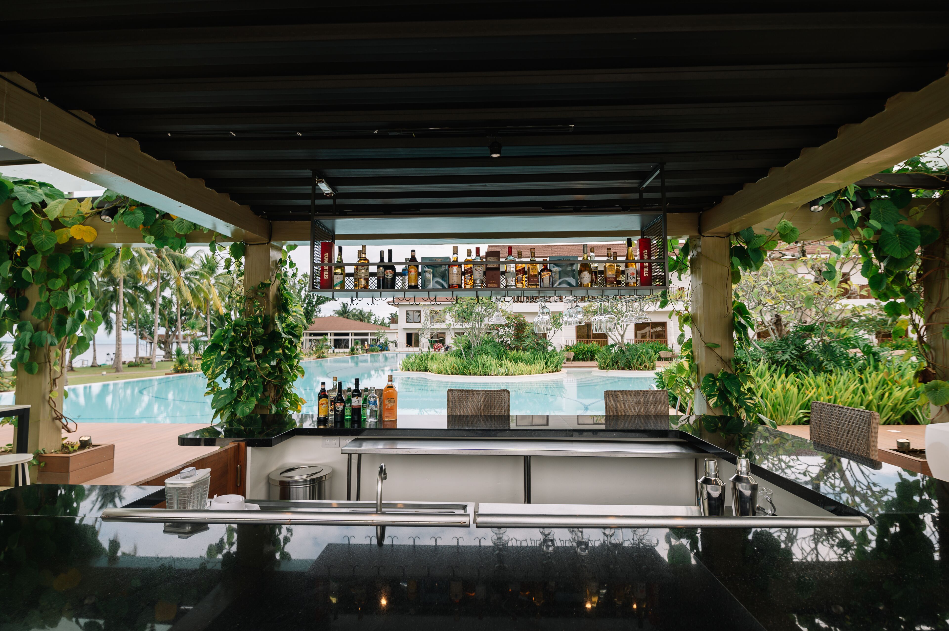 A poolside bar with a view of a pool and a building in the background.