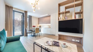 Un salon moderne comprenant un canapé, un coin repas, une cuisine et un téléviseur.