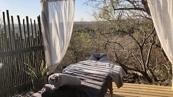 Relax in a serene outdoor massage area with a pergola and views of the surrounding landscape.