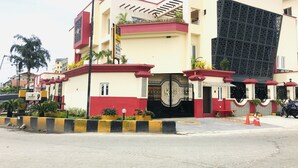 A building with a gated entrance, a staircase, and a signboard.
