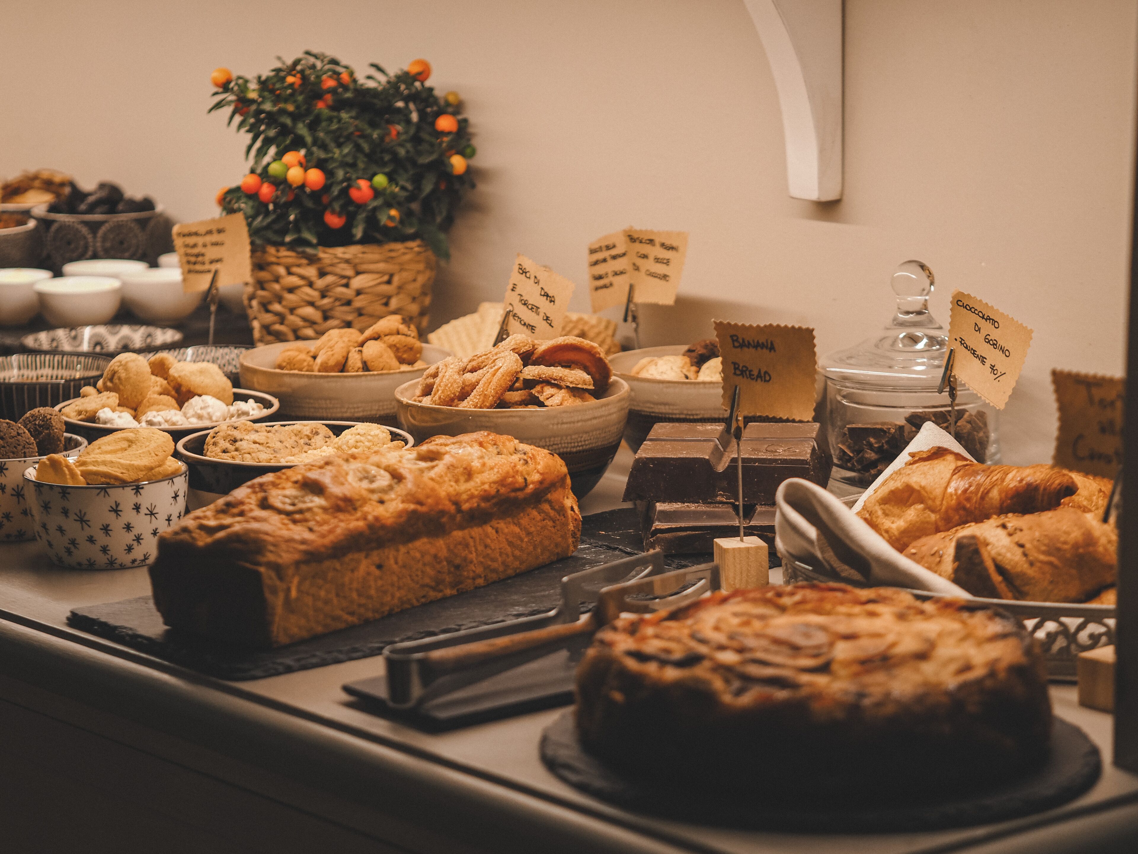 A buffet with various baked goods, including bread, pastries, and cookies.