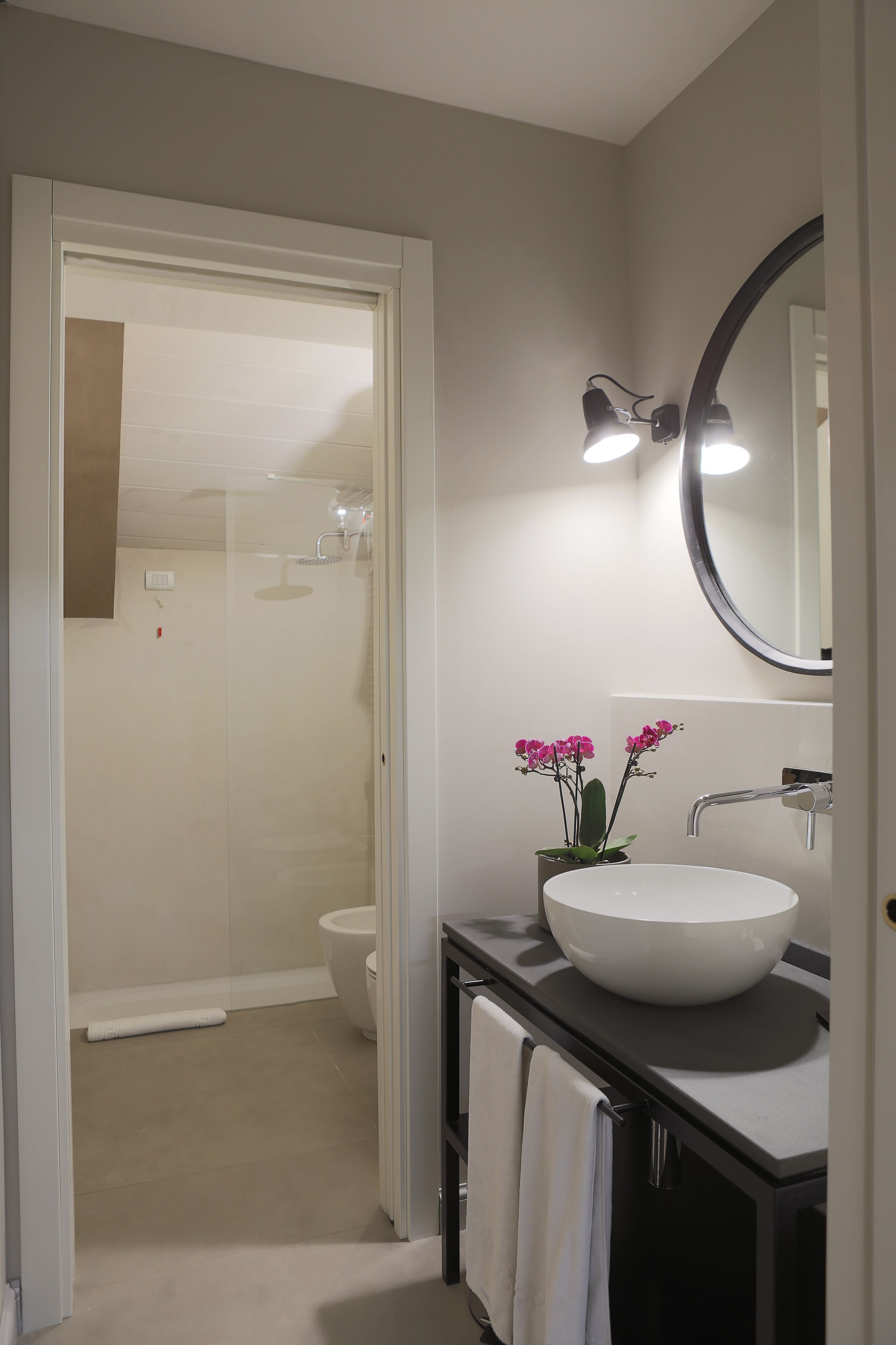 A bathroom with a white sink, a mirror, and a shower.