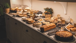 A buffet with various food items and a decorative plant.