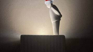 Un manichino con un cappello da Babbo Natale su una piattaforma.
