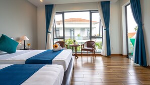 A hotel room with two beds, a balcony, and a view of a building. - Golden Star Villa Hoi An (Da Nang)