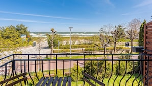 A balcony with a view of the beach and ocean.