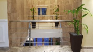 Ein modernes Interieur mit einer Holzwand, einem Metallgeländer und einem Blumentopf.