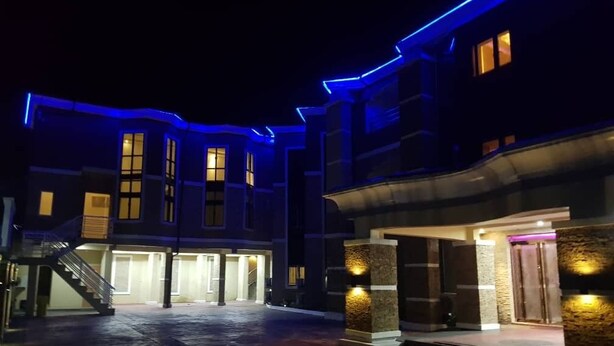 Ein Hotel mit Eingangsbereich, überdachtem Gang, Treppe und einer gut beleuchteten Fassade.