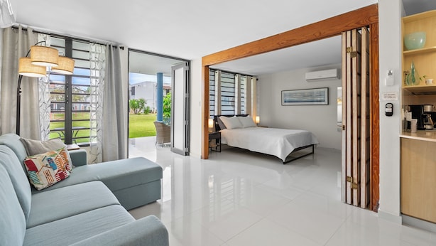 Una habitación de hotel moderna con sofá, cama y zona de cocina.