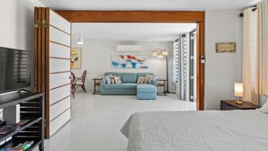 Una habitación de hotel moderna con una cama grande, un televisor, un sofá y un comedor.