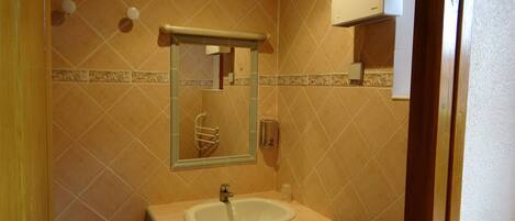 Ein Badezimmer mit Waschbecken, Spiegel und Handtuchhalter.