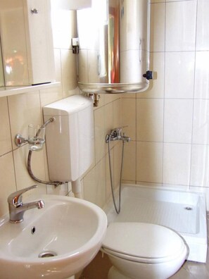 A bathroom with a toilet, sink, and shower. - Hostel Domestika (Bitola)