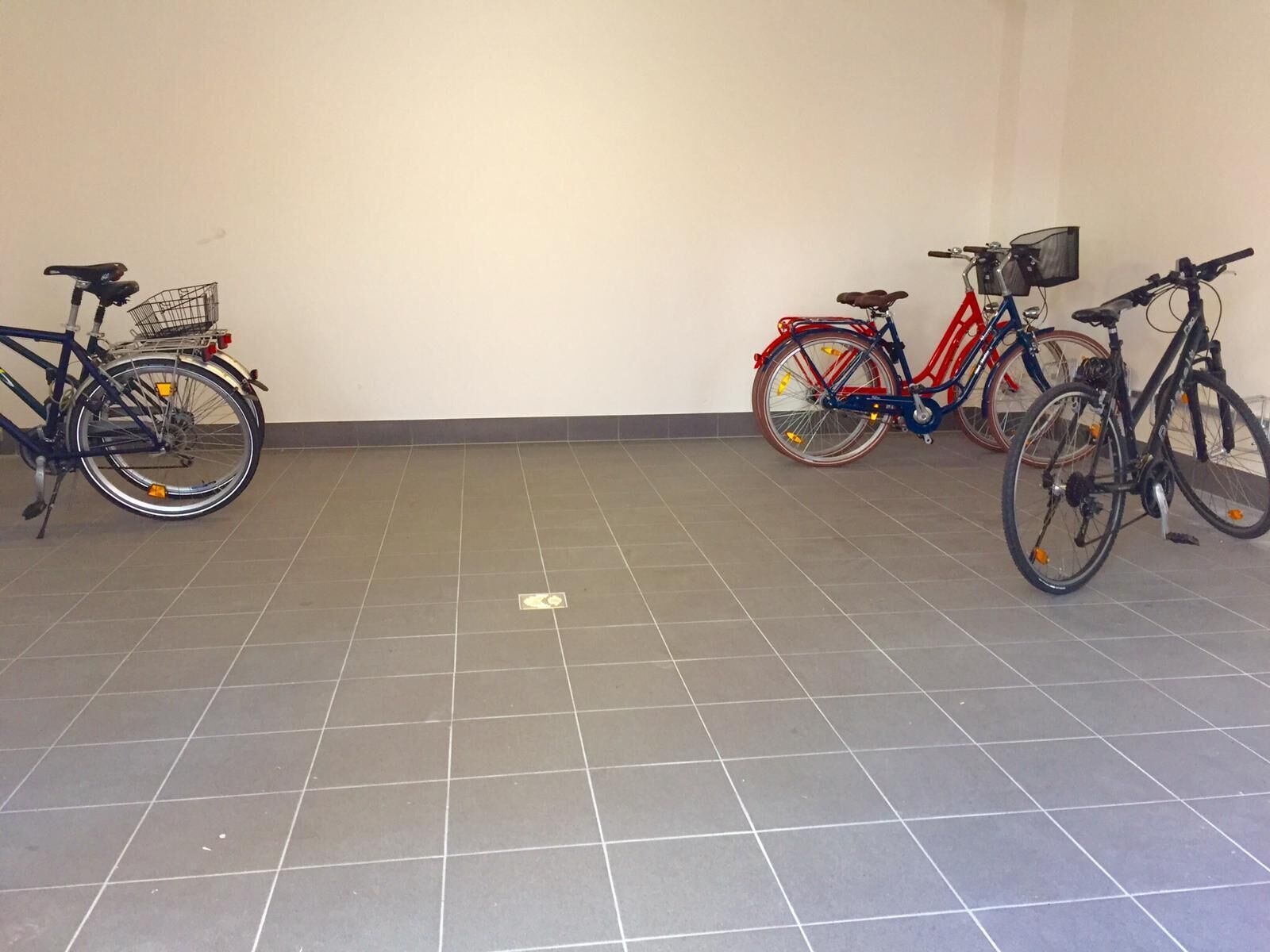 A tiled floor with bicycles parked against the wall.