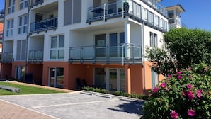 A multi-story residential building with balconies, large windows, and a parking area. - Residenz Windjammer (Cuxhaven)