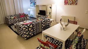 A living room with a sofa set, a dining table, and a TV. - Villa Pandora - Angela & Michali (Platanias)