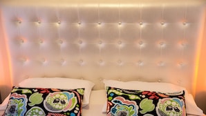 A bed with a tufted headboard, two pillows with colorful patterns, and a white bedspread. - Villa Pandora - Angela & Michali (Platanias)