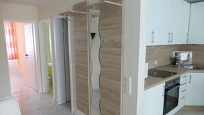 A modern kitchen with white cabinets, a built-in oven, and a countertop with a sink. - Haus Seemöwe (Cuxhaven)