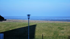 Eine begrünte Fläche mit einer Straßenlaterne und Blick auf das Meer.