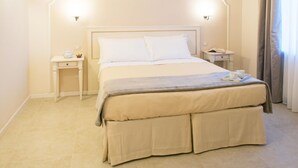 Ein ordentlich eingerichtetes Hotelzimmer mit einem großen Bett, Nachttischen und einer Lampe.