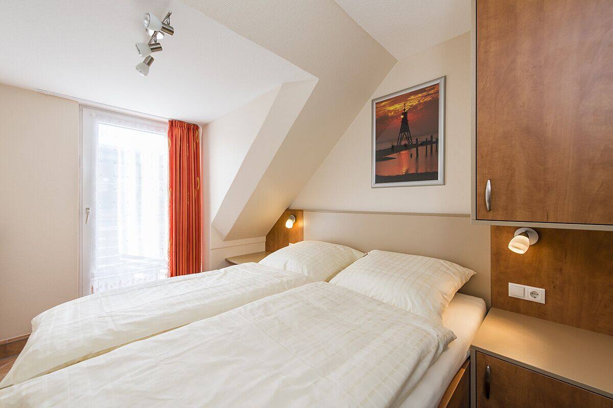 A hotel room with two beds, a large window with curtains, a painting on the wall, and a wooden cabinet.
