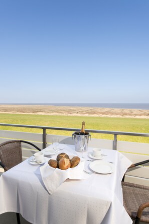 Mesa lista para comer con vista a la playa y al océano.