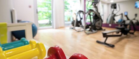 A gym with exercise equipment, including dumbbells and treadmills.