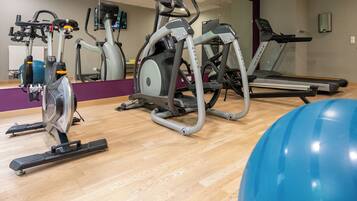 A gym with various exercise equipment including treadmills, an elliptical, and a stationary bike.