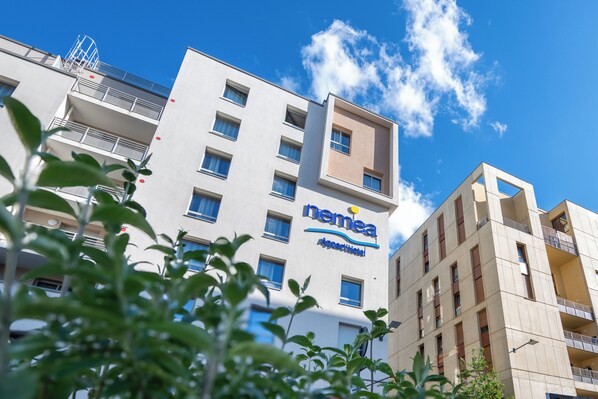 A modern hotel building with a clear sky and a few clouds. - Nemea Appart Hotel Grand Cœur Nancy Centre (Nancy)