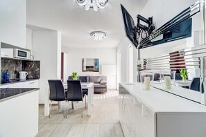 Una cocina moderna con comedor, televisor integrado y un amplio ventanal.