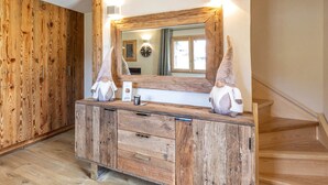A wooden vanity with a mirror, two gnome figurines, and a small bottle on the counter. - Cozy Chalet - 1 BR - 4 Pers - Terrace - Parking (La Clusaz)