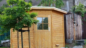 A wooden cabin with a door, steps, and a small porch area. - Ferienhof Gräfe - Apartment "Spring meadow" with terrace, pool & sauna (Meißen)