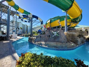 Un espace de parc aquatique comprenant une piscine, des toboggans et une décoration sur le thème des pirates.