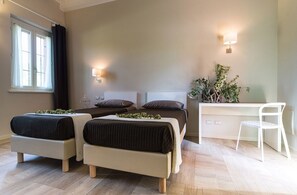 A bedroom with two beds, a desk, and a chair. - Cascina Galizia (Cuggiono)