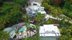 A resort with multiple buildings, a swimming pool, and lush tropical vegetation.