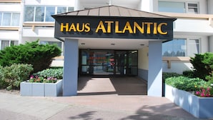 L’entrée de Haus Atlantic se distingue par son design moderne, avec une enseigne bien visible et un chemin qui mène à l’entrée.
