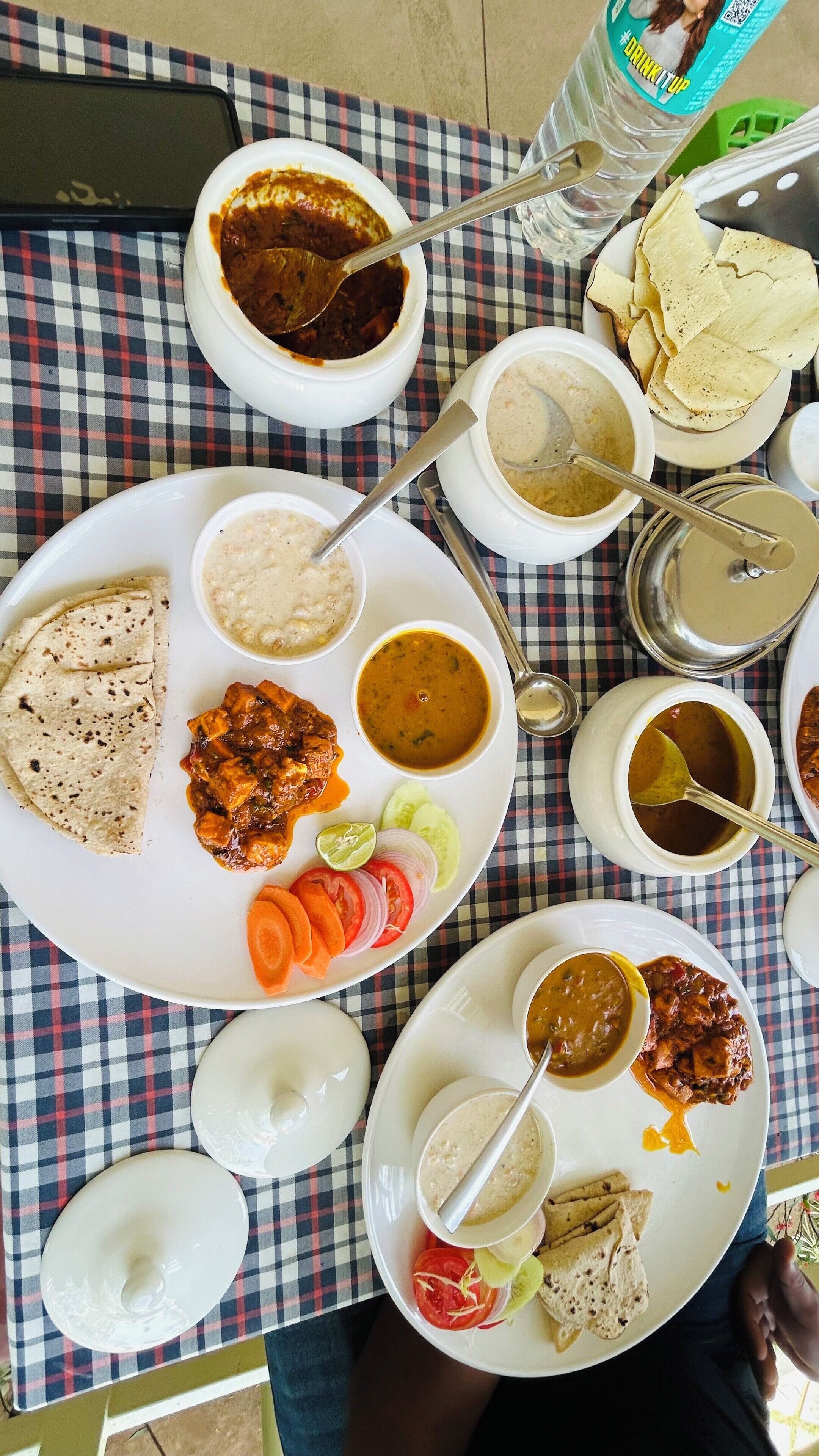 Una mesa con varios platos, incluyendo curries, arroz y panes planos, indicando una comida.