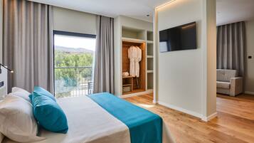 Un dormitorio con cama, televisor, armario y balcón.